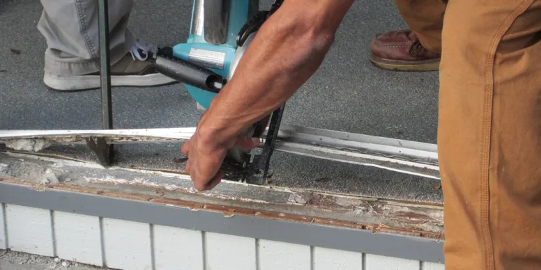 A person using an angle grinder to cut the edge of a pool.
