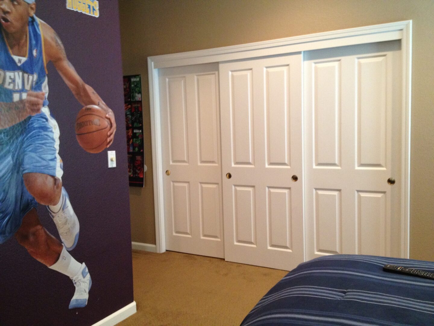 A bedroom with a basketball mural and a bed