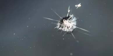 A bullet hole in the glass of a window.