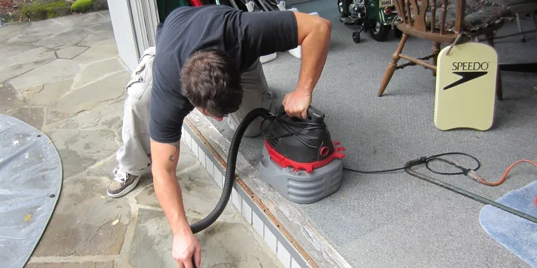 A man is using an air hose to inflate the floor.