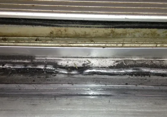 A close up of the bottom of a metal door